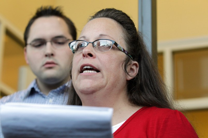 Rowan County Clerk Kim Davis, with son Nathan Davis, a deputy clerk, reads a statement to the press outside the Rowan County Courthouse on Sept. 14, 2015 in Morehead, Ky. Davis did not interfere with marriage licenses issued after she returned to work. (Pablo Alcala/Lexington Herald-Leader/TNS)