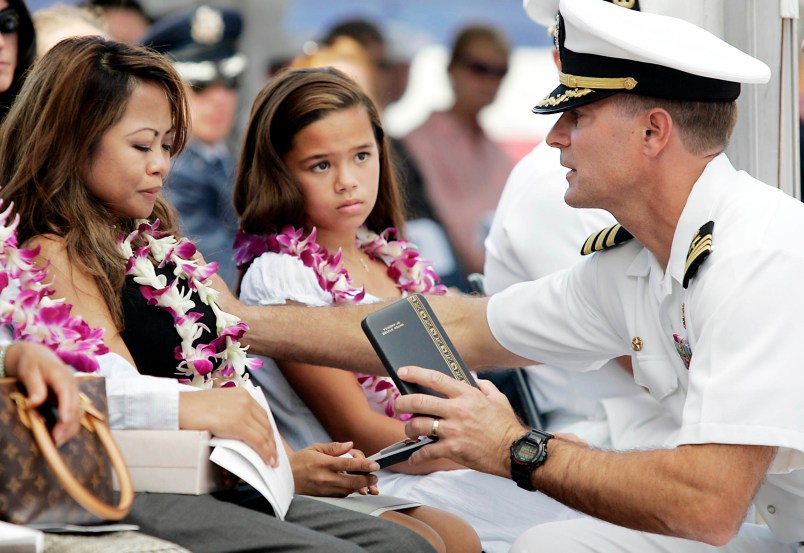 PEARL HARBOR, HI - JULY 11:  During a memorial service held at the National Memorial Cemetery of the Pacific in Honolulu, Naval Rear Admiral Joseph Maguire, Commander of the Naval Special Warfare Command (right) presents an award post humorously to Norminda Healy, wife of Daniel Richard Healy, a navy SEAL killed in action while conducting combat operations in Afghanistan, July 11, 2005.   (Photo by Marco Garcia/Getty Images)