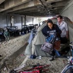 PICO RIVERA, CA JANUARY 05, 2016 ---  Los Angeles sheriff deputy Michael Galvan, left, warns a couple living under Freeway 5 bridge along San Gabriel River in Pico Rivera. LASD deputies ventured out in pouring rain looking for homeless encampments along river to warn inhabitants  about danger of flooding and to provide them information of nearby shelters. (Irfan Khan / Los Angeles Times)