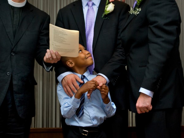 WASHINGTON, DC  - JULY 26:  (L-R)  Newly-adopted son Cardel, 6 smiles at his two adoptive parents,  Kelly Vielmo (C) and Jack Montgomery (R) get married by Rev. __________ in Washington, DC on Thursday, July 26, 2012.  The same sex couple legally adopted Cardel and his two sisters Ravyn, 2 and Raine, 3 earlier in the day.  The children are all siblings from the same mother and have been living with Jack and Kelly for about a year now.  They decided to do both events on the same day out of convenience for family members who came to town.   (Photo by Linda Davidson / The Washington Post)