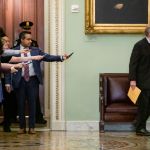WASHINGTON, DC - JANUARY 30: Reporters reach out with their cell phones and audio recorders trying to get a statement from Sen. Lamar Alexander (R-TN) as he passes by during a recess in the Senate impeachment trial of President Donald Trump on January 30, 2020 in Washington, DC. The trial has entered into the second day of the question phase where Senators have the opportunity to submit written questions to the House managers and President Trump's defense team. (Photo by Samuel Corum/Getty Images) *** Local Caption *** Lamar Alexander