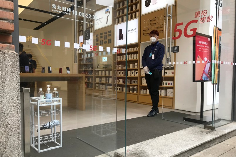 A store worker waits for customers at a re-opened retail street in Wuhan in central China's Wuhan province on Monday, March 30, 2020. Shopkeepers in the city at the center of China’s virus outbreak were reopening Monday but customers were scarce after authorities lifted more of the anti-virus controls that kept tens of millions of people at home for two months. (AP Photo/Olivia Zhang)