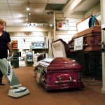 Patricia Jo Ralph, funeral director at T.M. Ralph Funeral Homes in Plantation, Florida, vacuums around a casket, April 3, 2009. The funeral industry is suffering in the recession as people choose cheaper services or cremation. Some funeral homes are cutting costs by doing things themselves. (Lilly Echeverria/Miami Herald/MCT)