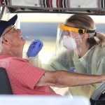 A resident of The Villages, Fla. gets tested for the coronavirus with a nasal swab at a drive-through site that accomodates golf carts, at The Villages Polo Club, Monday, March 23, 2020. The testing site is being operated by UF Health, with University of Florida medical students performing the tests, and is limited to residents of The Villages only. (Joe Burbank/Orlando Sentinel/TNS)