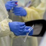 A detail photo of a nasal swab held by a Registered Nurse wearing gloves and a protective gown that she is about to use to do a test on a patient in their car at Penn State Health St. Joseph where they are conducting drive through coronavirus / COVID-19 testing and have taken extra precautions regarding entry to the hospital,  in Bern Township, PA Friday afternoon March 27, 2020.