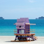 Two cruise ships are shown anchored offshore past a lifeguard tower, Tuesday, March 31, 2020, in Miami Beach, Fla. (AP Photo/Wilfredo Lee)