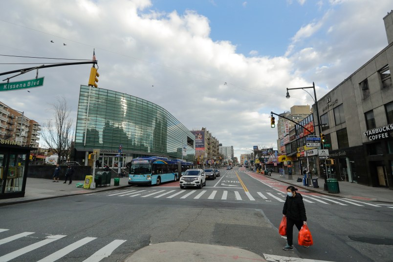 A woman wearing personal protective equipment crosses Main Street Wednesday, April 1, 2020, in the Flushing section of the Queens borough of New York. The new coronavirus causes mild or moderate symptoms for most people, but for some, especially older adults and people with existing health problems, it can cause more severe illness or death. (AP Photo/Frank Franklin II)