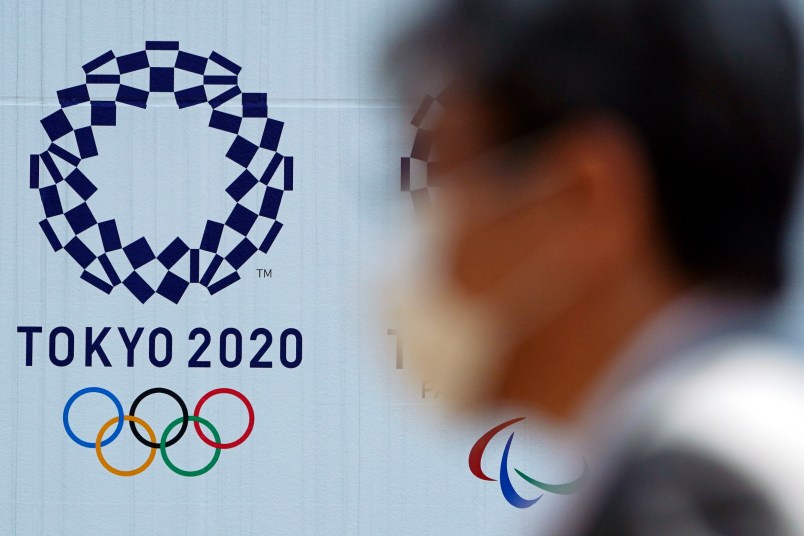 A man wearing a protective face mask walks near the Tokyo 2020 Olympics Thursday, April 2, 2020, in Tokyo. The new coronavirus causes mild or moderate symptoms for most people, but for some, especially older adults and people with existing health problems, it can cause more severe illness or death. (AP Photo/Eugene Hoshiko)