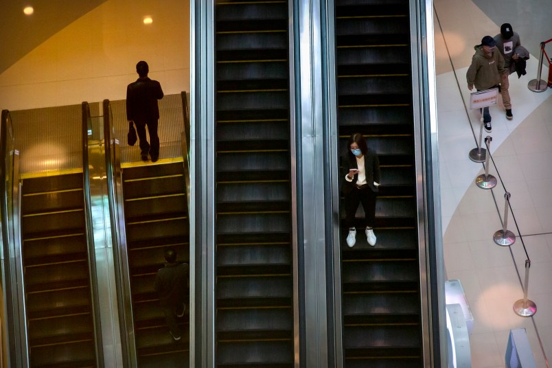 A woman wears a face mask to protect against the spread of the new coronavirus as she rides an escalator at a shopping mall in Beijing, Wednesday, April 15, 2020. China reported several dozen new coronavirus cases on Wednesday, mostly from overseas. (AP Photo/Mark Schiefelbein)