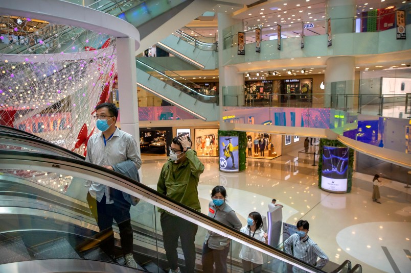 ***HOLD FOR CHINA GDP STORY***In this April 15, 2020 photo, people wear facemasks to protect against the spread of the new coronavirus cleans as they ride an escalator at a shopping mall in Beijing. (AP Photo/Mark Schiefelbein)