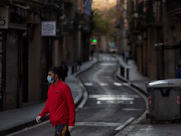 RAVAL DISTRICT, BARCELONA, SPAIN - 2020/04/05: A man wearing a face mask as a preventive measure against the COVID-19 coronavirus walks on an empty street. Due to the confinement order in Spain decreed by the Spanish President Pedro Sanchez to fight against the Coronavirus (Covid-19) the cities are practically empty. (Photo by Xavi Herrero/SOPA Images/LightRocket via Getty Images)