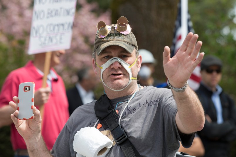 OLYMPIA, WA - APRIL 19: A man wearing a cutout mask gathered with hundreds of othersat a rally titled “Hazardous Liberty! Defend the Constitution!” to protest the stay-at-home order, at the Capitol building on April 19, 2020 in Olympia, Washington. Washington state Governor Jay Inslee instituted the order last month to slow the spread COVID-19. Many who attended did not follow social distancing guidelines or wear masks but were there to support their right to assemble. They advocated that people should be allowed to go back to work. (Photo by Karen Ducey/Getty Images)