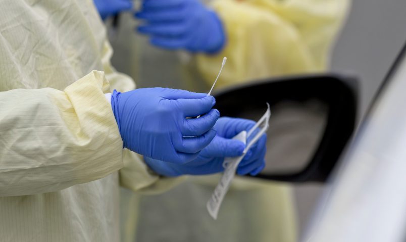 A detail photo of a nasal swab held by a Registered Nurse wearing gloves and a protective gown that she is about to use to do a test on a patient in their car at Penn State Health St. Joseph where they are conducting drive through coronavirus / COVID-19 testing and have taken extra precautions regarding entry to the hospital,  in Bern Township, PA Friday afternoon March 27, 2020.