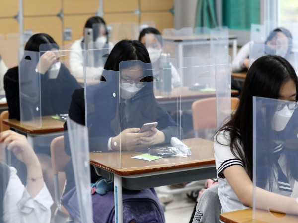 Senior students wait for class to begin with plastic boards placed on their desks at  Jeonmin High School in Daejeon, South Korea, Wednesday, May 20, 2020. South Korean students began returning to schools Wednesday as their country prepares for a new normal amid the coronavirus pandemic. (Kim Jun-beom/Yonhap via AP)