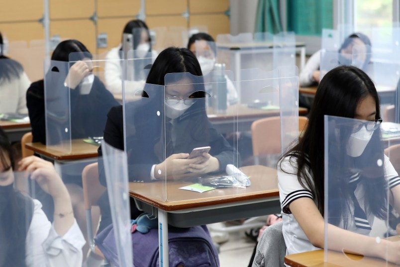 Senior students wait for class to begin with plastic boards placed on their desks at  Jeonmin High School in Daejeon, South Korea, Wednesday, May 20, 2020. South Korean students began returning to schools Wednesday as their country prepares for a new normal amid the coronavirus pandemic. (Kim Jun-beom/Yonhap via AP)