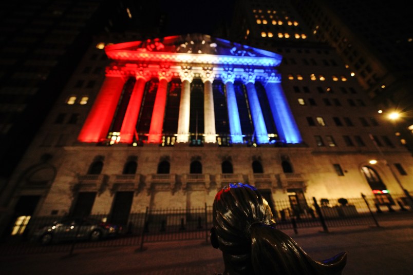 A view of the fearless girl with the New York Stock Exchange on the background lit in different colors as support for Frontliners during Coronavirus pandemic on May 5, 2020. (Photo by John Nacion/NurPhoto)