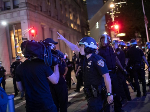 A police officer shouts at Associated Press video journalist Robert Bumsted ordering him to go home despite journalists being exempt from the imposed curfew as he films arrests being made on Tuesday, June 2, 2020, in New York. (AP Photo/Wong Maye-E)