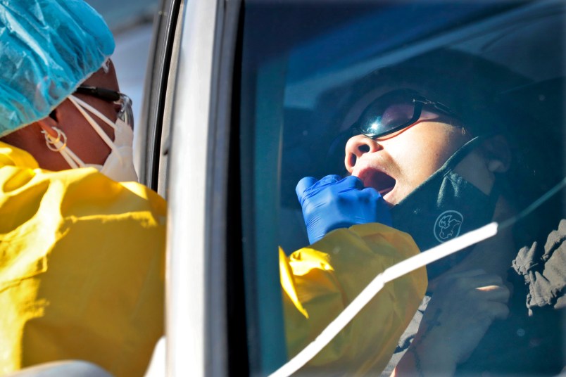 People get tested for COVID-19 at a drive through testing site hosted by the Puente Movement migrant justice organization Saturday, June 20, 2020, in Phoenix. Latinos are especially vulnerable to infection because they tend to live in tight quarters with multiple family members and have jobs that expose them to others. They also have a greater incidence of health conditions like diabetes that put them at higher risk for contracting COVID-19. (AP Photo/Matt York)