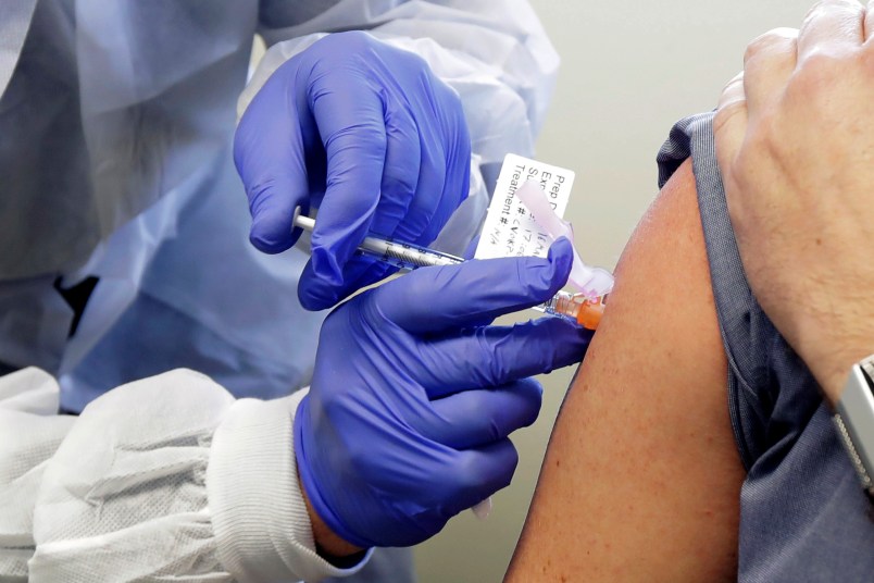 Neal Browning receives a shot in the first-stage safety study clinical trial of a potential vaccine for the COVID-19 coronavirus, Monday, March 16, 2020, at the Kaiser Permanente Washington Health Research Institute in Seattle. Browning is the second patient to receive the shot in the study. (AP Photo/Ted S. Warren)