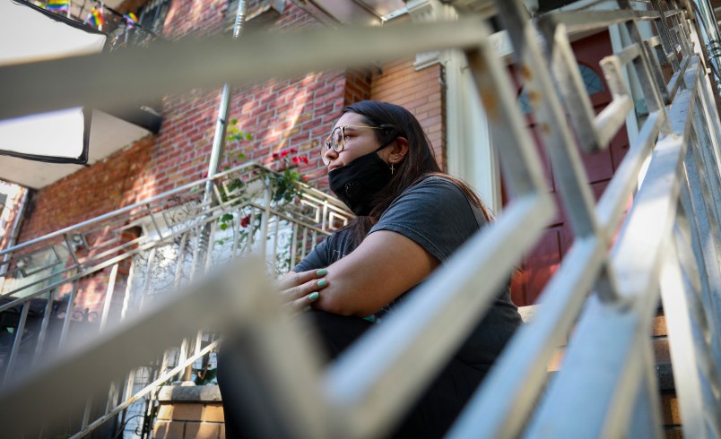 Natalia Afonso, 27, an international student from Brazil at Brooklyn College, sit on a stoop outside her home during an interview, Thursday July 9, 2020, in New York.  Afonso, who is studying teaching education and finished her first semester this spring, said she has lived in the U.S. for 7 years and “I don’t see myself moving back to Brazil at this point.  (AP Photo/Bebeto Matthews)
