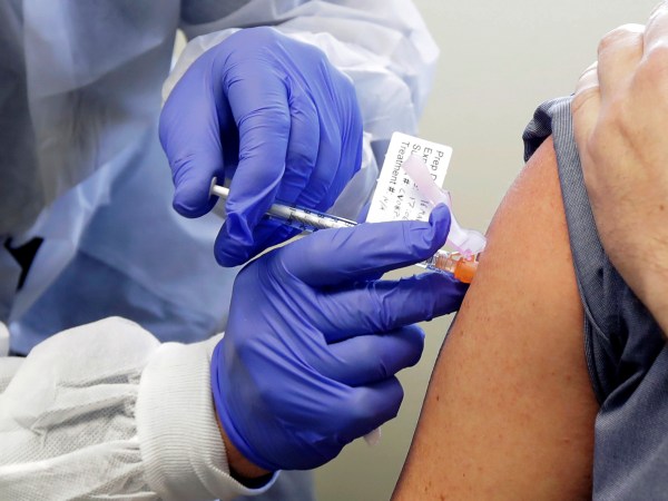 Neal Browning receives a shot in the first-stage safety study clinical trial of a potential vaccine for the COVID-19 coronavirus, Monday, March 16, 2020, at the Kaiser Permanente Washington Health Research Institute in Seattle. Browning is the second patient to receive the shot in the study. (AP Photo/Ted S. Warren)