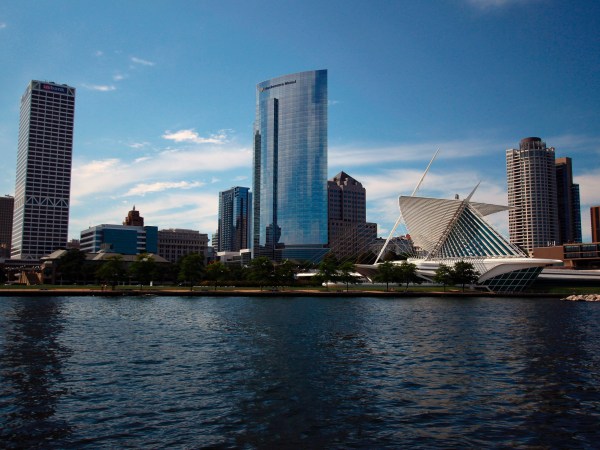 ***HOLD FOR MONDAY***This Aug. 13, 2020 photo shows the skyline of downtown Milwaukee, the location of a scaled down Democratic National Convention. About 50,000 visitors were expect to inject about $250 million into the economy of the key presidential battleground state.  But now, thanks to the ongoing coronavirus pandemic, the convention is nearly entirely online, with all of the major speakers, including presumptive nominee Joe Biden, skipping the trip to Milwaukee. It would have been the first time Milwaukee, a city of 1.6 million, hosted a presidential nominating convention. (AP Photo/Carrie Antlfinger)