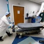 HOUSTON, TEXAS—JULY 1, 2020—An empty bed is moved back to the emergency room after brining in another COVID-19 patient. At United Memorial Medical Center in Houston, Texas, Dr. Joseph Varon leads a team to fight the increasing number of coronavirus patients in the expanded Covid-19 ward on July 1, 2020.  (Carolyn Cole/Los Angeles Times)