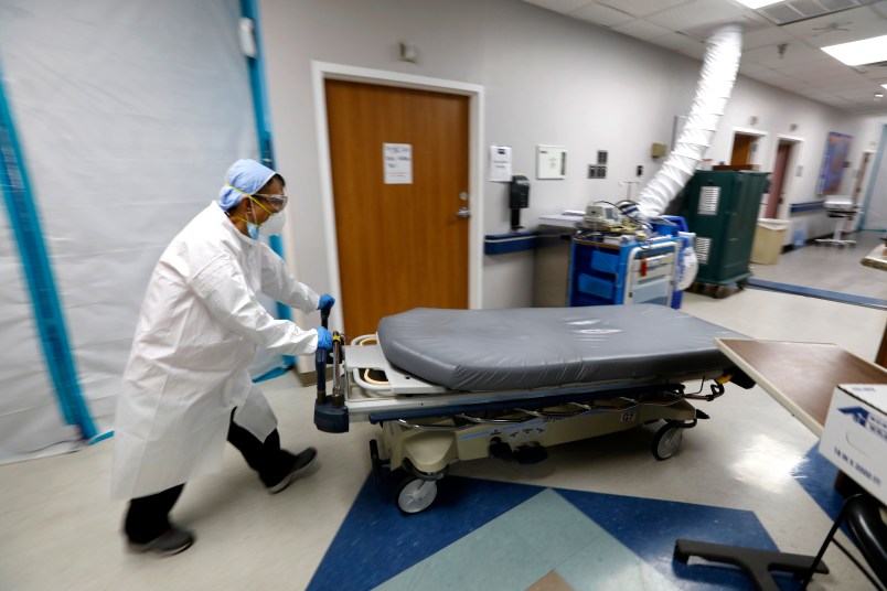 HOUSTON, TEXAS—JULY 1, 2020—An empty bed is moved back to the emergency room after brining in another COVID-19 patient. At United Memorial Medical Center in Houston, Texas, Dr. Joseph Varon leads a team to fight the increasing number of coronavirus patients in the expanded Covid-19 ward on July 1, 2020.  (Carolyn Cole/Los Angeles Times)