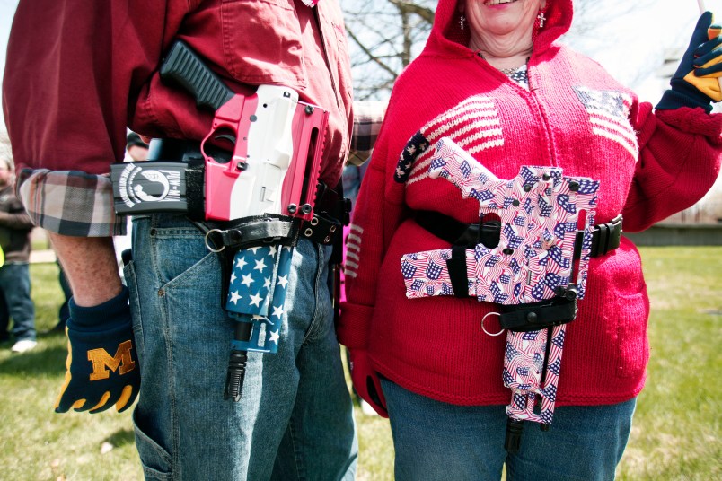 ROMULUS, MI - APRIL 24: Chris (right) and Marty Welch of Cadillac, Michigan, carry decorated Olympic Arms .223 pistols at a rally for supporters of Michigan's Open Carry law  April 27, 2014 in Romulus, Michigan. The march was held to attempt to demonstrate to the general public what the typical open carrier is like. (Photo by Bill Pugliano/Getty Images)