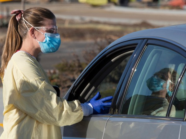 HOLD FOR KEITH RIDLER STORY Physician assistant Nicole Thomas conducts a COVID-19 examination in the parking lot at Primary Health in Boise, Idaho, on Tuesday, Nov. 24, 2020. (AP Photo/Otto Kitsinger)