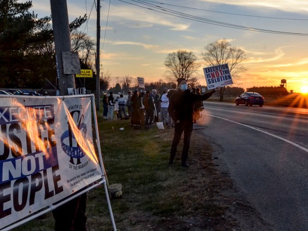Protesters line Prairieton Road across from the Federal Death Chamber in Terre Haute, IN. during a protest against the execution of Brandon Bernard on Thursday evening. (Austen Leake/Tribune-Star via AP)