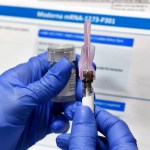 Nurse Kathe Olmstead prepares a shot as the world's biggest study of a possible COVID-19 vaccine, developed by the National Institutes of Health and Moderna Inc., gets underway Monday, July 27, 2020, in Binghamton, N.Y. (AP Photo/Hans Pennink)