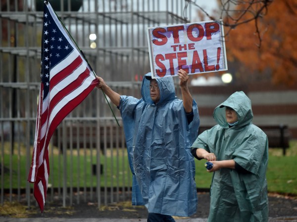WILKES-BARRE, PENNSYLVANIA, UNITED STATES - 2020/11/11: A protester holds a placard and a flag during the demonstration.A group of approximately 25 people in support of Donald Trump marched around Public Square shouting "Stop the Steal" and demanding a recount of votes in Pennsylvania. (Photo by Aimee Dilger/SOPA Images/LightRocket via Getty Images)