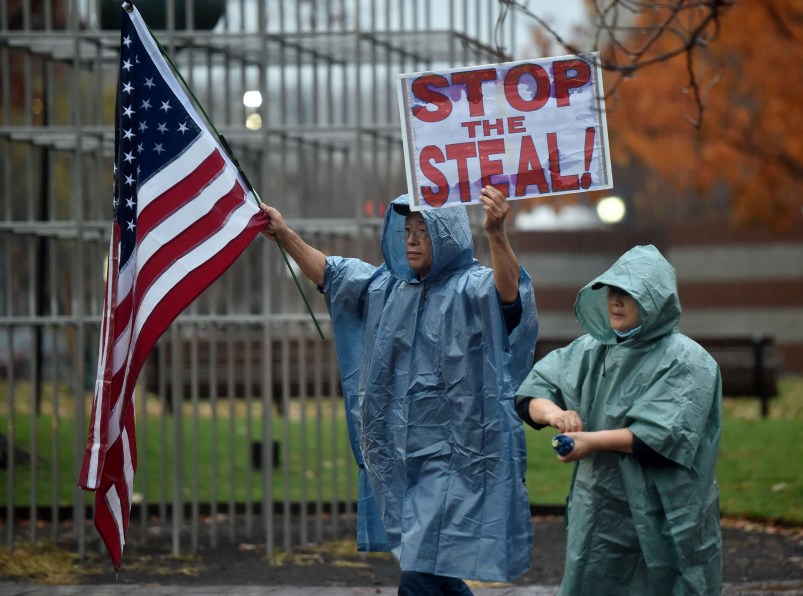 WILKES-BARRE, PENNSYLVANIA, UNITED STATES - 2020/11/11: A protester holds a placard and a flag during the demonstration.A group of approximately 25 people in support of Donald Trump marched around Public Square shouting "Stop the Steal" and demanding a recount of votes in Pennsylvania. (Photo by Aimee Dilger/SOPA Images/LightRocket via Getty Images)