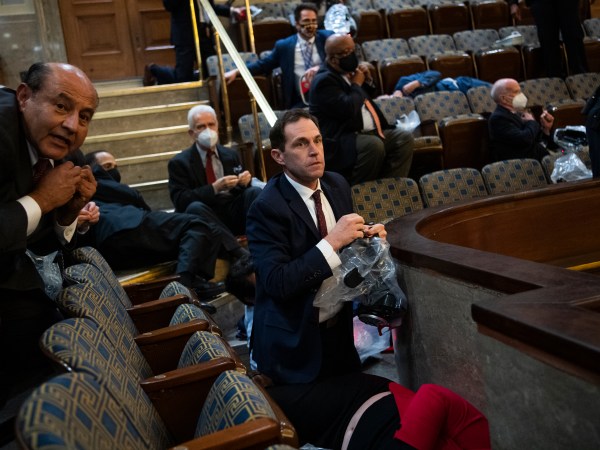 UNITED STATES - JANUARY 6: Rep. Jason Crow, D-Colo.,  and other members take cover as protesters attempt to disrupt the joint session of Congress to certify the Electoral College vote on Wednesday, January 6, 2021. (Photo By Tom Williams/CQ Roll Call)