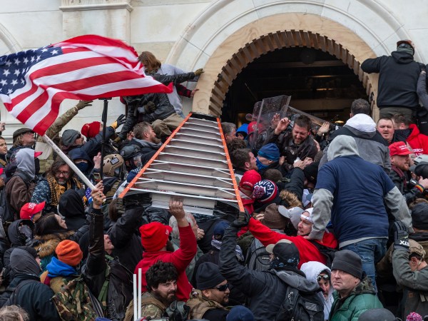 WASHINGTON DC, DISTRICT OF COLUMBIA, UNITED STATES - 2021/01/06: Rioters clash with police using big ladder trying to enter Capitol building through the front doors. Rioters broke windows and breached the Capitol building in an attempt to overthrow the results of the 2020 election. Police used batons and tear gas grenades to eventually disperse the crowd. Rioters used metal bars and tear gas as well against the police. (Photo by Lev Radin/Pacific Press/LightRocket via Getty Images)