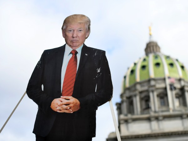 HARRISBURG, PA - JANUARY 17: A cardboard effigy of President Donald Trump is lowered while people demonstrate against the president outside the Pennsylvania Capitol Building on January 17, 2021 in Harrisburg, Pennsylvania. Supporters of President Trump are expected to gather at state capitol buildings throughout the nation today to protest the presidential election results and the upcoming inauguration of President-elect Joe Biden. (Photo by Mark Makela/Getty Images)
