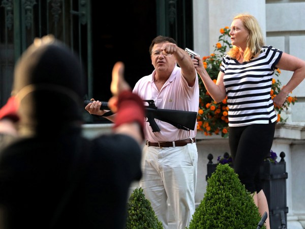 Armed homeowners Mark T. and Patricia N. McCloskey stand in front their house as they confront protesters marching to St. Louis Mayor Lyda Krewson's house on June 28, 2020. The protesters called for Krewson's resignation for releasing the names and addresses of residents who suggested defunding the police department. (Laurie Skrivan/St. Louis Post-Dispatch/TNS)