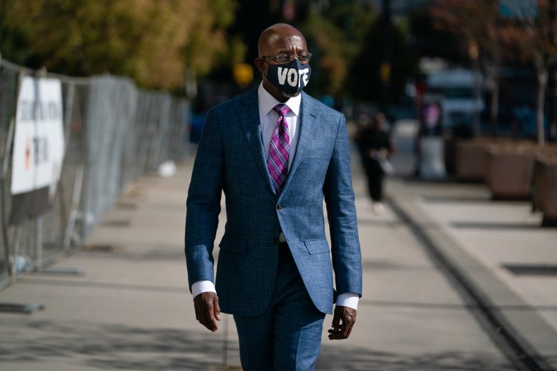 ATLANTA, GA - OCTOBER 21: Democratic U.S. senatorial candidate Raphael Warnock walks to State Farm Arena to cast his ballot on October 21, 2020 in Atlanta, Georgia. (Photo by Elijah Nouvelage/Getty Images)