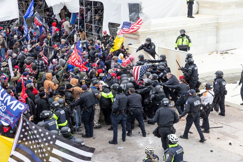 WASHINGTON DC, DISTRICT OF COLUMBIA, UNITED STATES - 2021/01/06: Pro-Trump protesters and police clash on top of the Capitol building. Rioters broke windows and breached the Capitol building in an attempt to overthrow the results of the 2020 election. Police used batons and tear gas grenades to eventually disperse the crowd. Rioters used metal bars and tear gas as well against the police. (Photo by Lev Radin/Pacific Press/LightRocket via Getty Images)