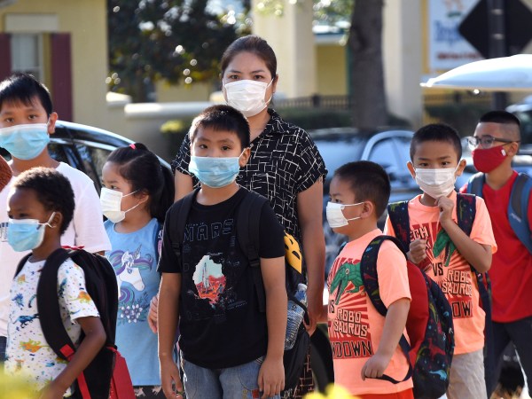 ORLANDO, FLORIDA, UNITED STATES - 2021/08/10: Students wearing face masks arrive on the first day of classes for the 2021-22 school year at Baldwin Park Elementary School. Due to the current surge in COVID-19 cases in Florida, Orange County public schools have implemented a face mask mandate for students for 30 days unless a parent chooses to opt out of the requirement. (Photo by Paul Hennessy/SOPA Images/LightRocket via Getty Images)