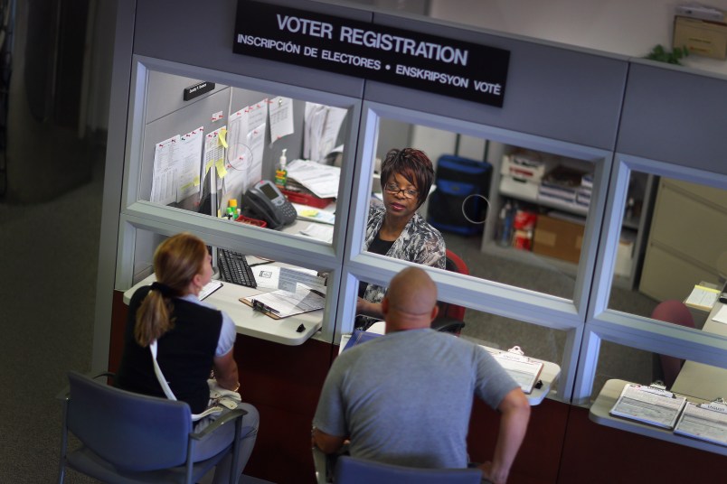 MIAMI, FL - OCTOBER 01:  Dorothy Torrence, from the Miami-Dade Elections Department, helps Yarelis Alvarez (L) and Alberto Alvarez fill out their voter registration forms on October 1, 2012 in Miami, Florida. As the October 9th deadline for people to register to vote in the upcoming election approaches according to the Florida Department of State, the number of people registering to vote is now averaging between 1,500 and 3,000 a day. After months of the Democrats questioning the motives of the Republican led legislator to purge non citizens and roll back early voting, the Republican Party was accused of using a firm to register voters that was providing false voter registration information. (Photo by Joe Raedle/Getty Images)