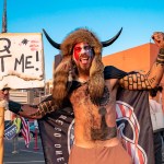 Jake A, 33, aka Yellowstone Wolf, from Phoenix, holds a QAnon sign, as he presents himself as a shamanist and consultant for the Trump supporters gathered in front of the Maricopa County Election Department where ballots are counted after the US presidential election in Phoenix, Arizona, on November 5, 2020. - President Donald Trump erupted on November 5 in a tirade of unsubstantiated claims that he has been cheated out of winning the US election as vote counting across battleground states showed Democrat Joe Biden steadily closing in on victory. (Photo by OLIVIER  TOURON / AFP) (Photo by OLIVIER  TOURON/AFP via Getty Images)